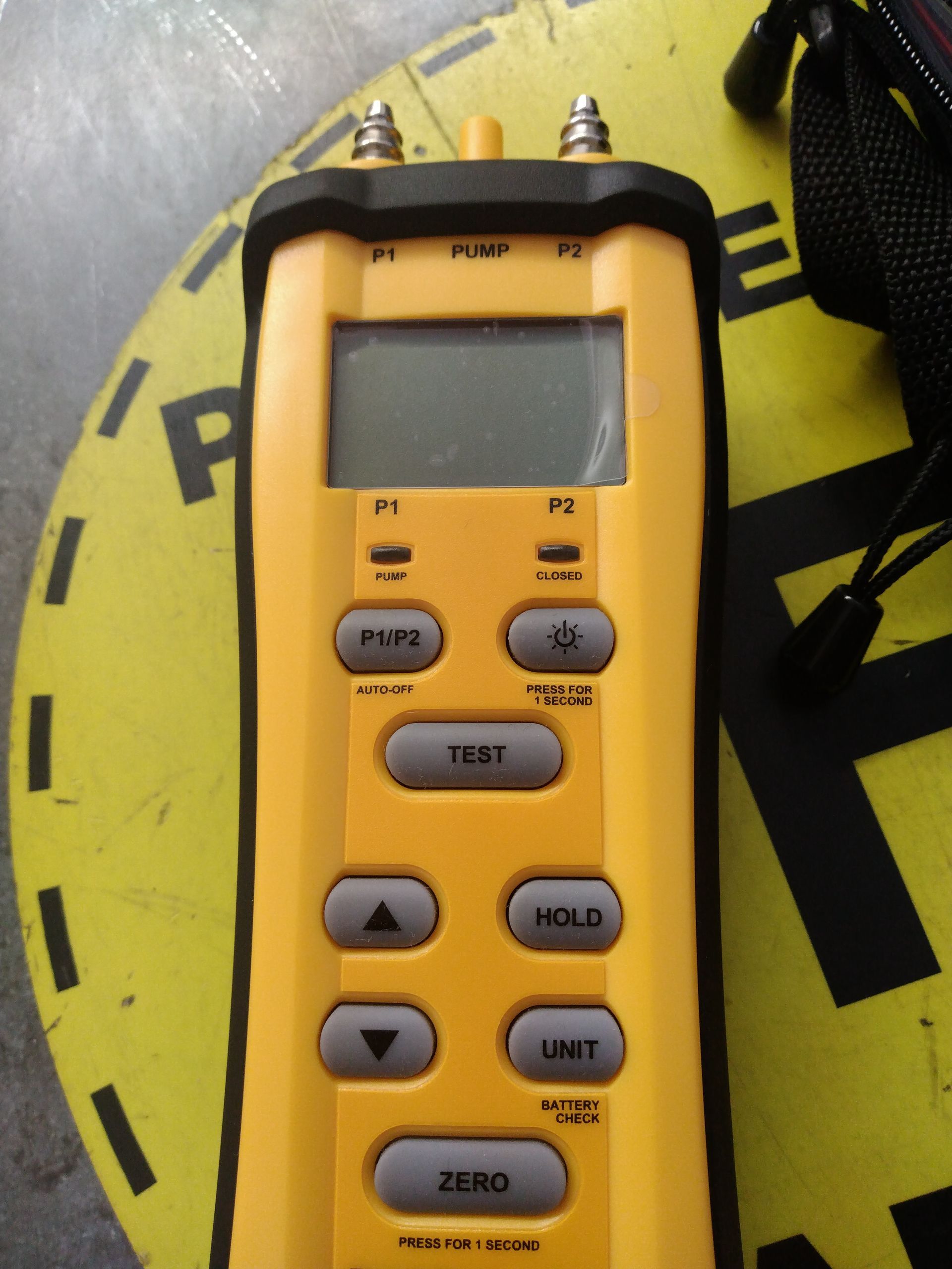 A yellow device with buttons that say test hold and zero