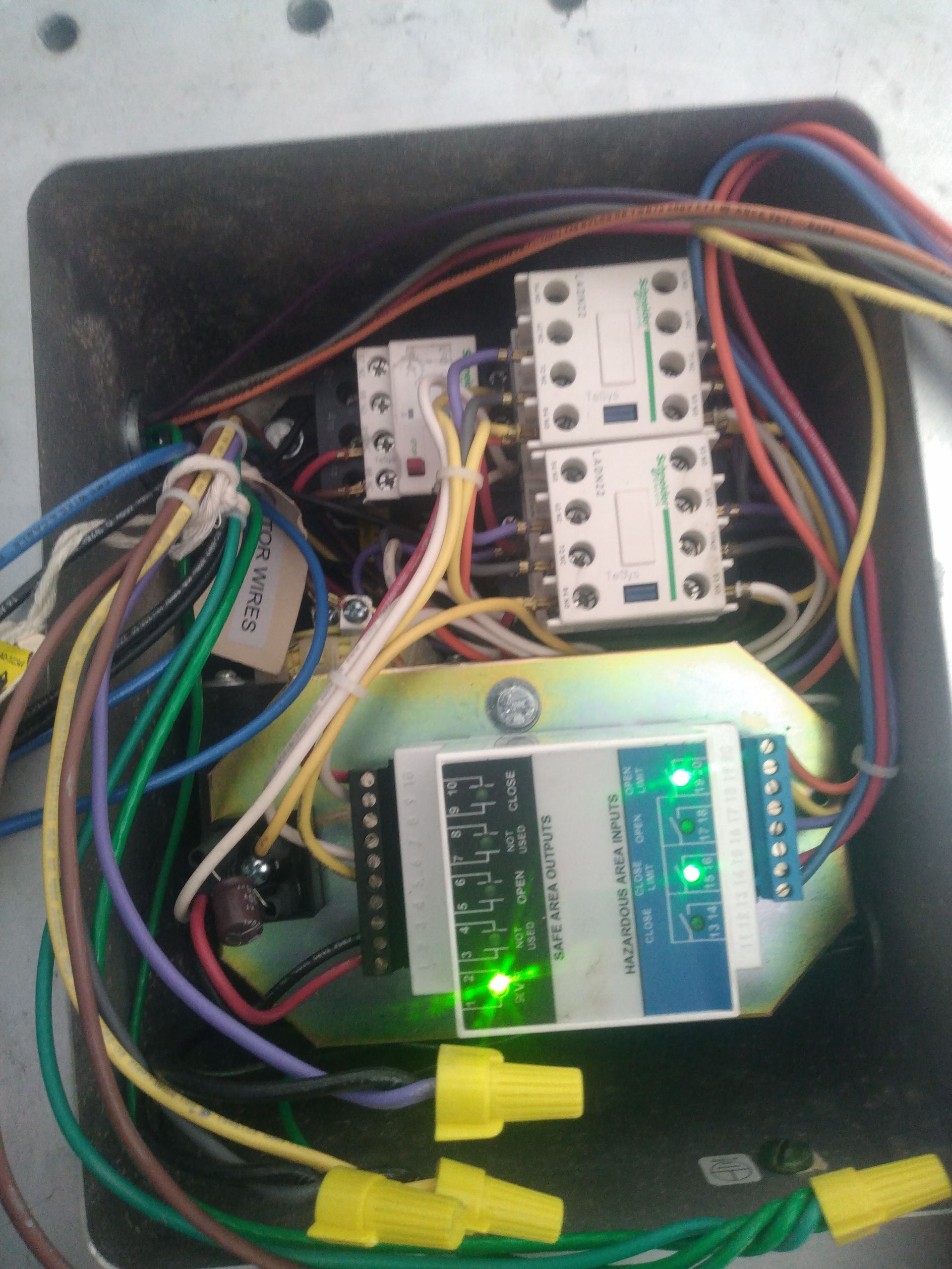 A bunch of wires are connected to a device that has a green light on it