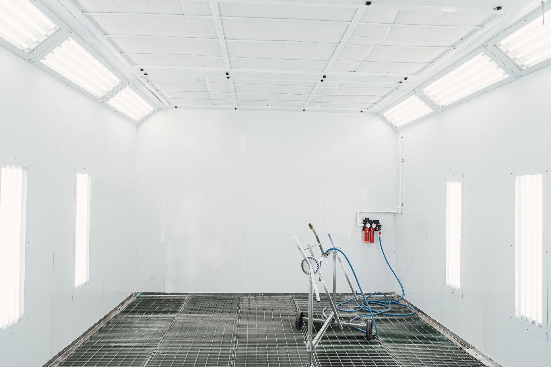 An empty paint booth with a cart in it.