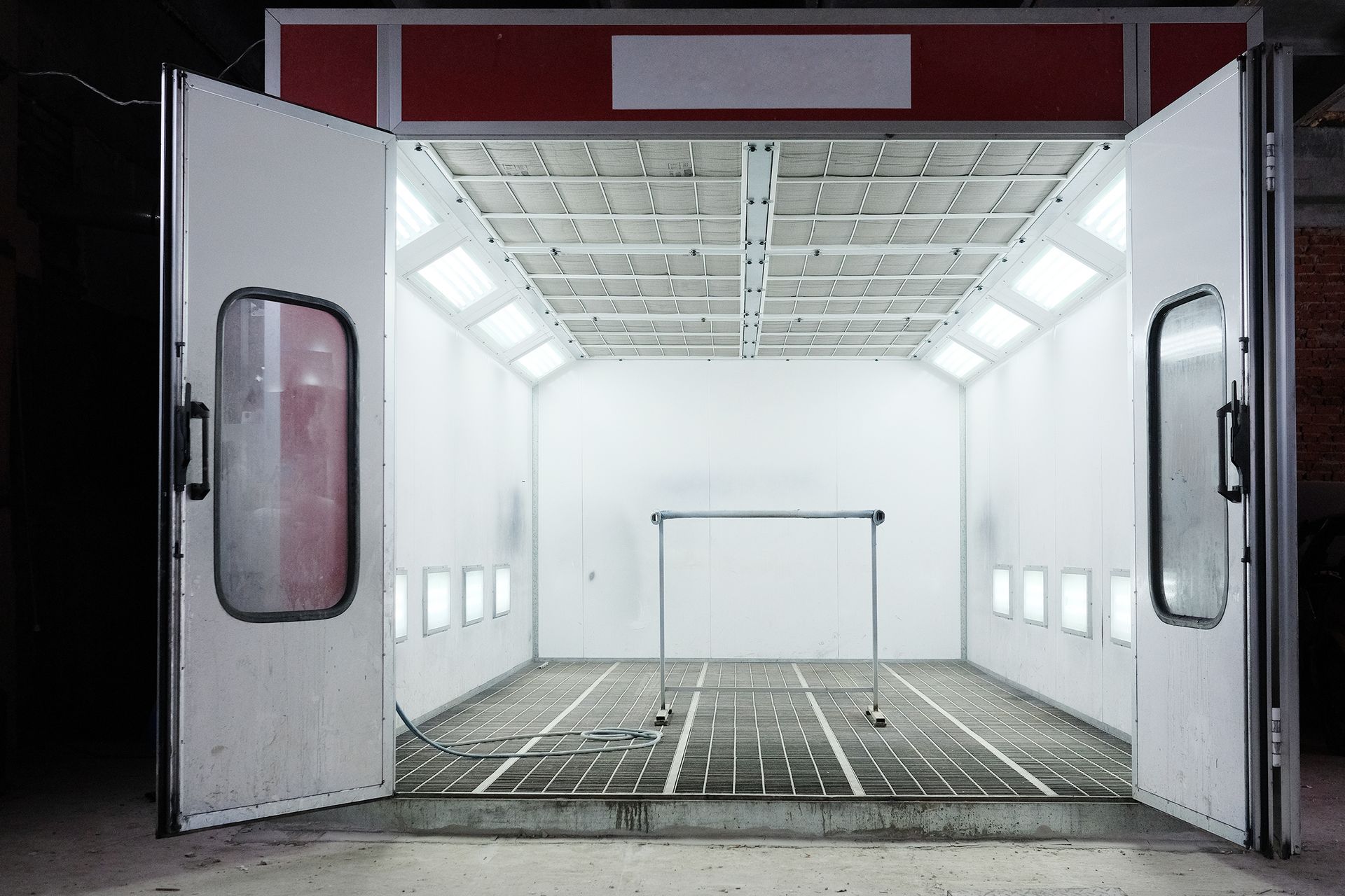 An empty paint booth with its doors open at night.