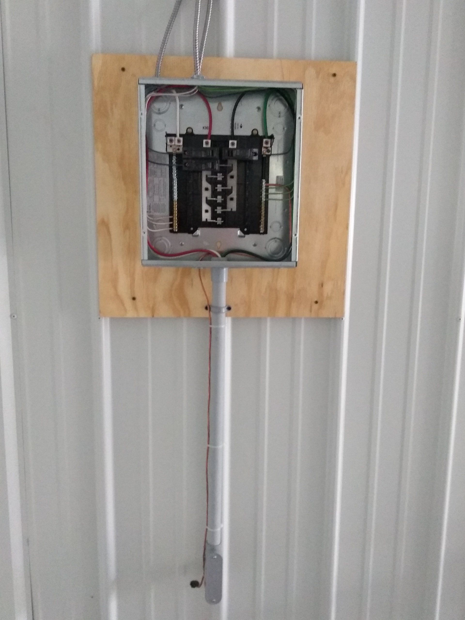 an electrical box mounted to a metal wall