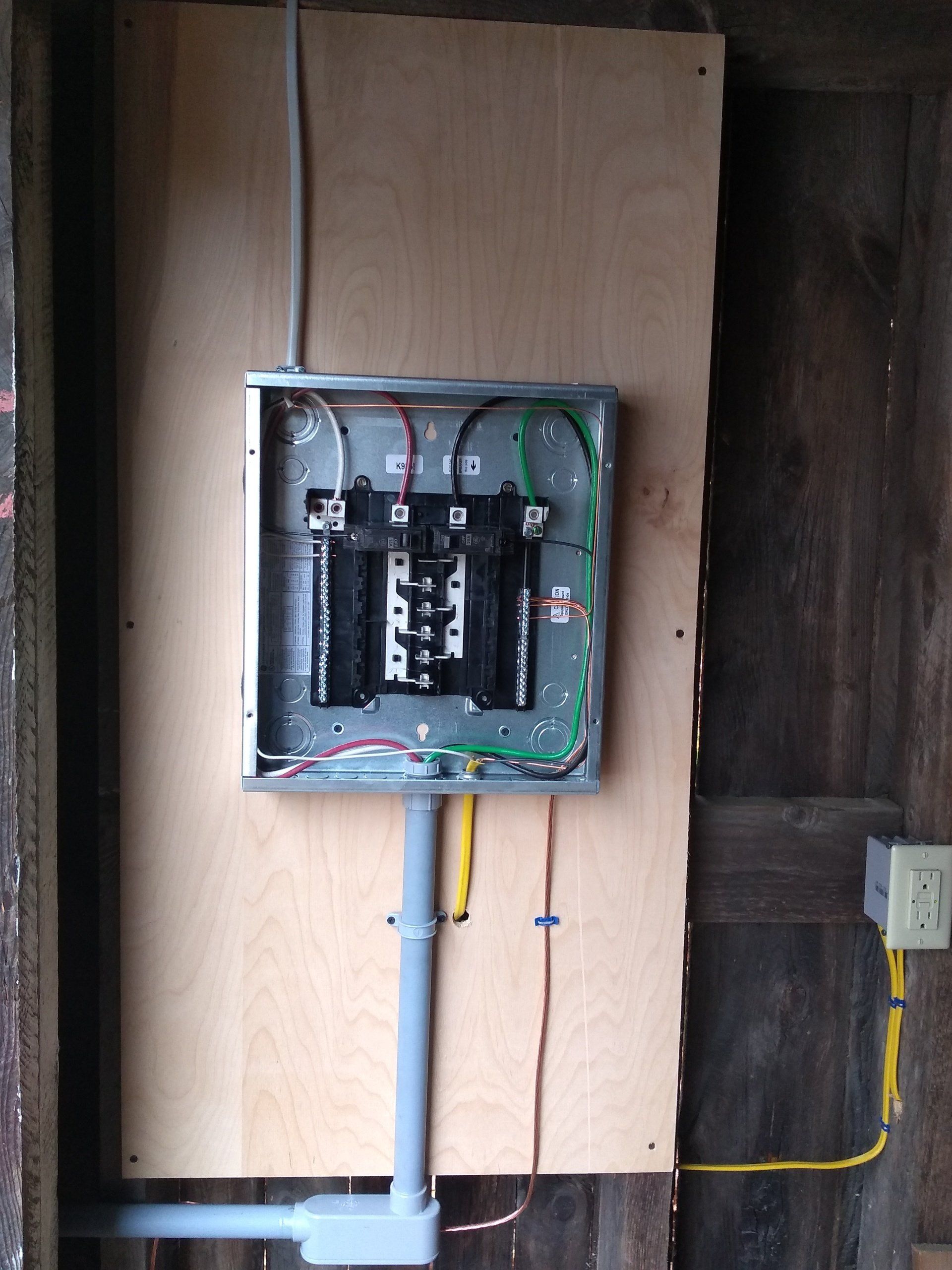 a electrical box is mounted on a wooden wall .