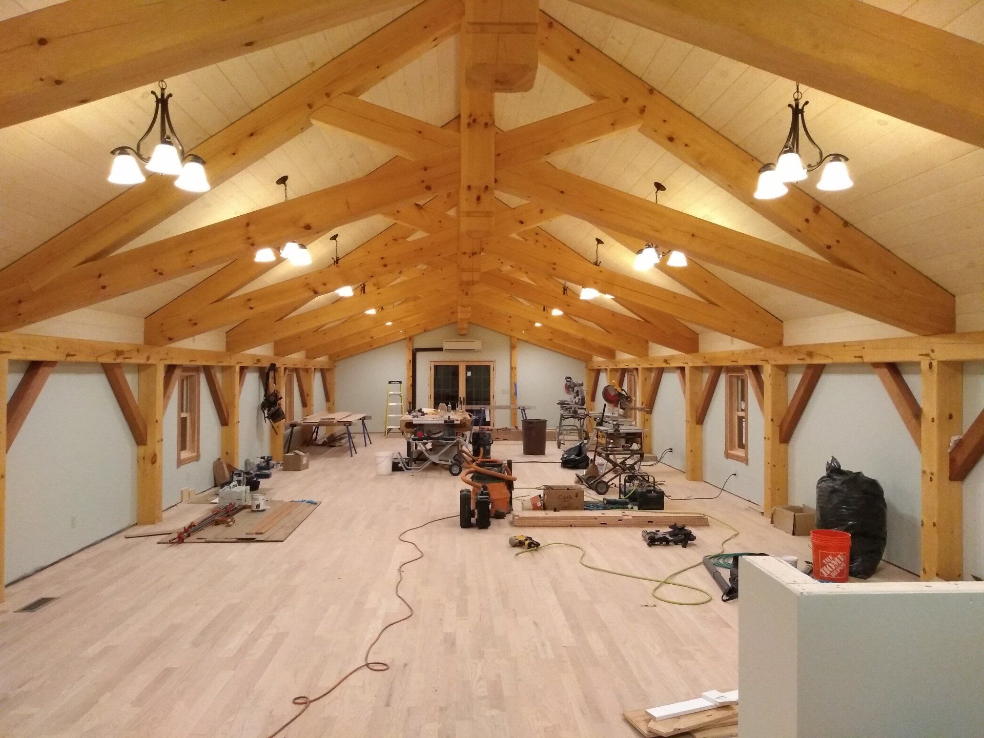 a large room with wooden vaulted ceiling and bright lights