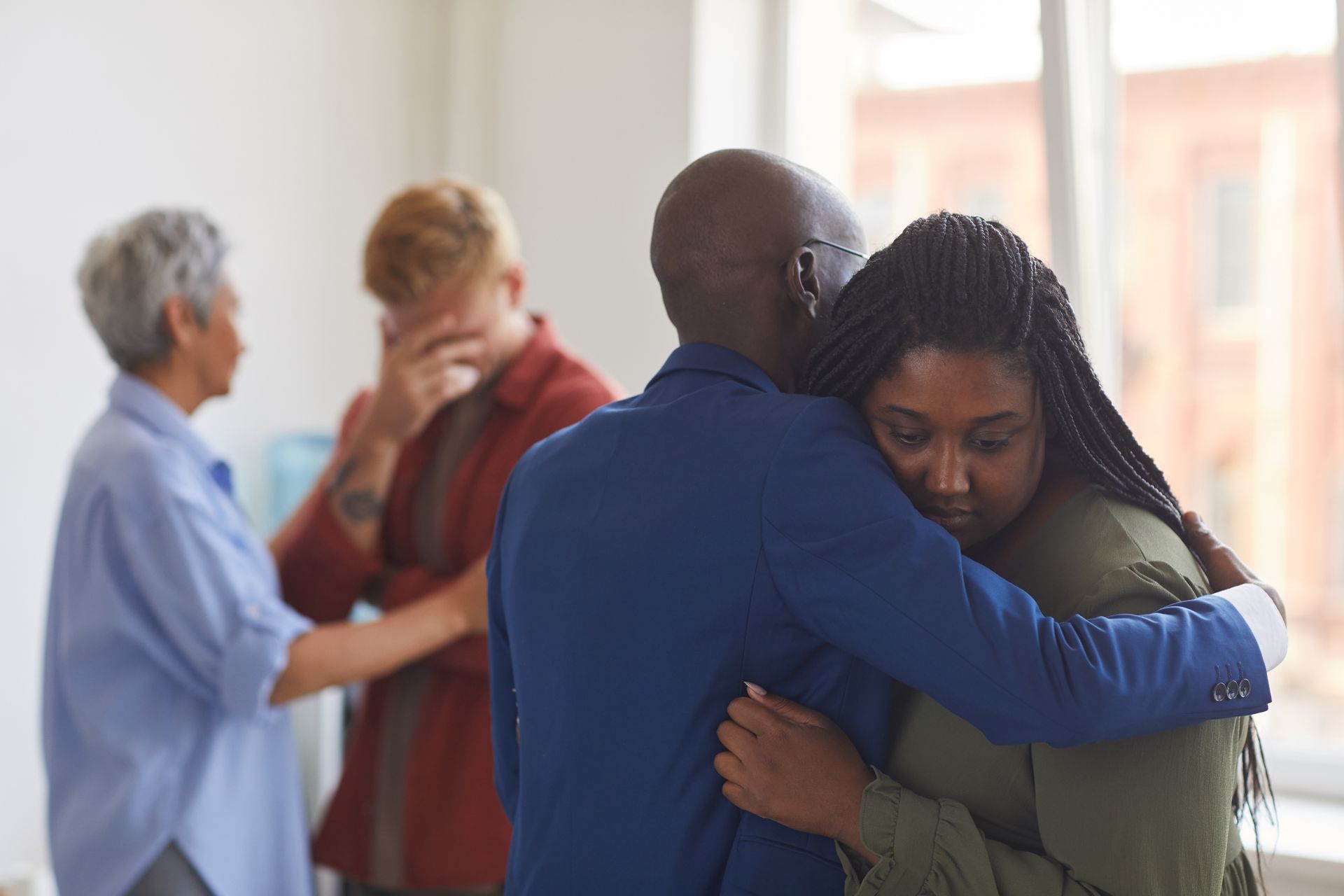 A group of people are hugging each other in a room.