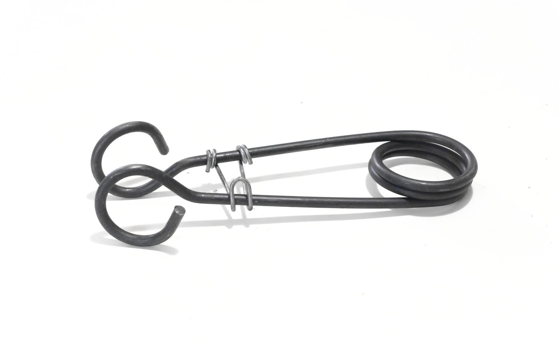Ressort en spirale métallique avec poignées et boucle, sur fond blanc.