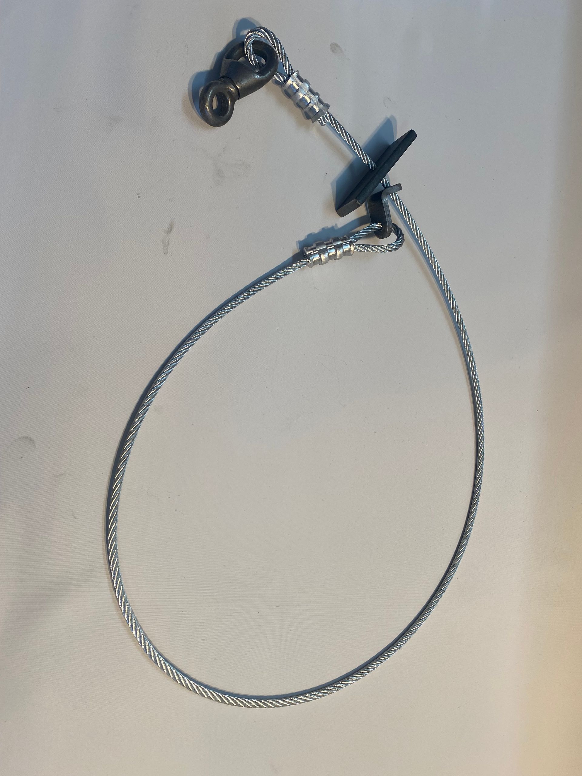 Boucle de câble argentée avec connecteurs métalliques et clip noir.