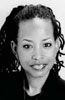 Black and white headshot of a person with curly hair smiling gently toward the camera.