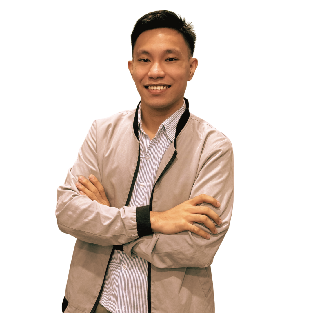 A smiling person wearing a light-colored jacket over a striped shirt stands with arms crossed against a white background.