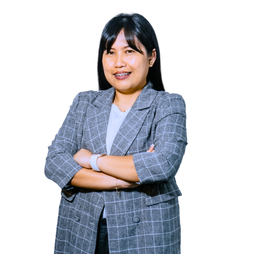 A person with dark hair and braces smiles with arms crossed, wearing a grey plaid blazer over a white shirt.