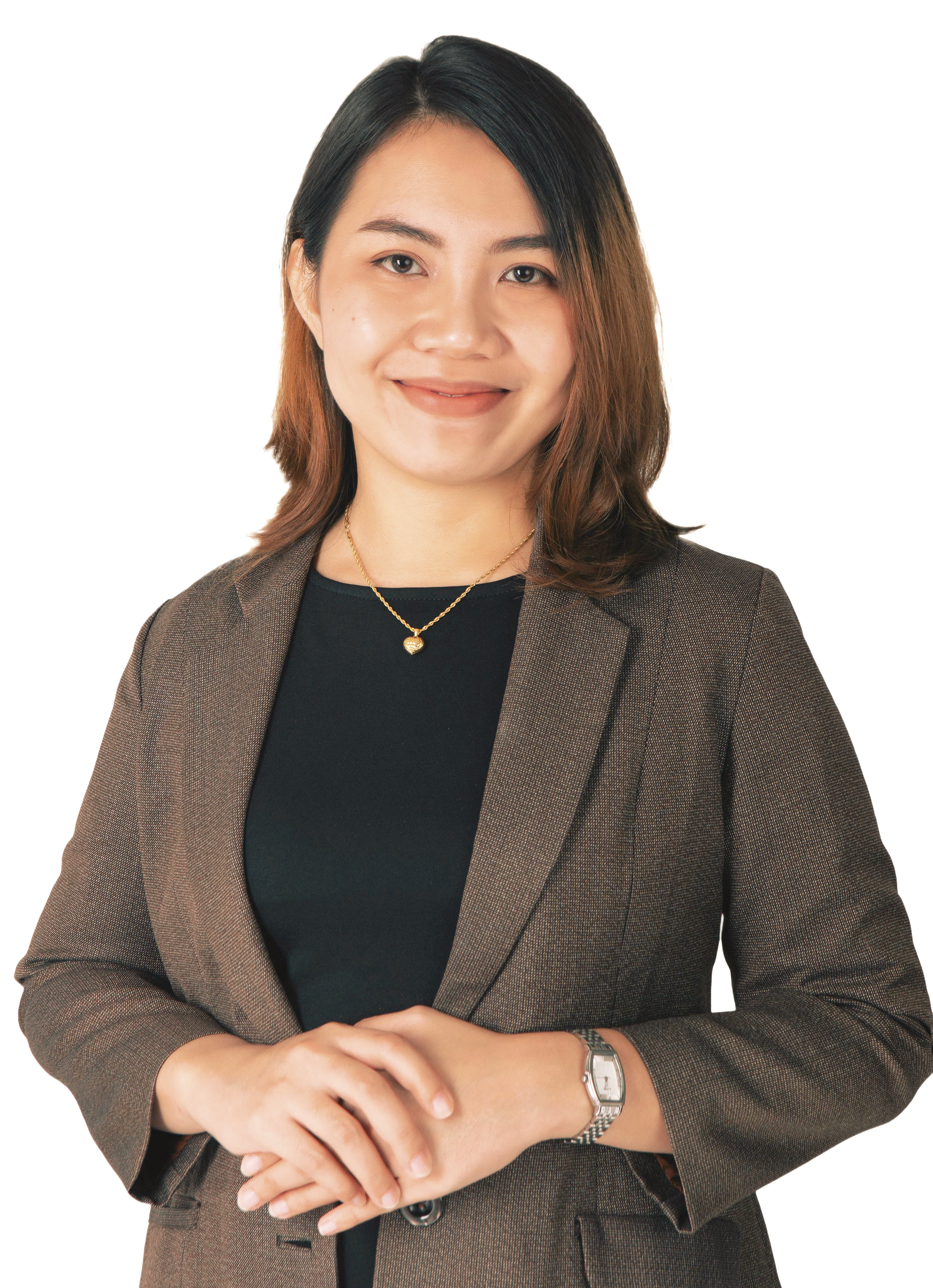 A person with shoulder-length hair wearing a dark blazer over a black top, smiling with hands clasped, white background.