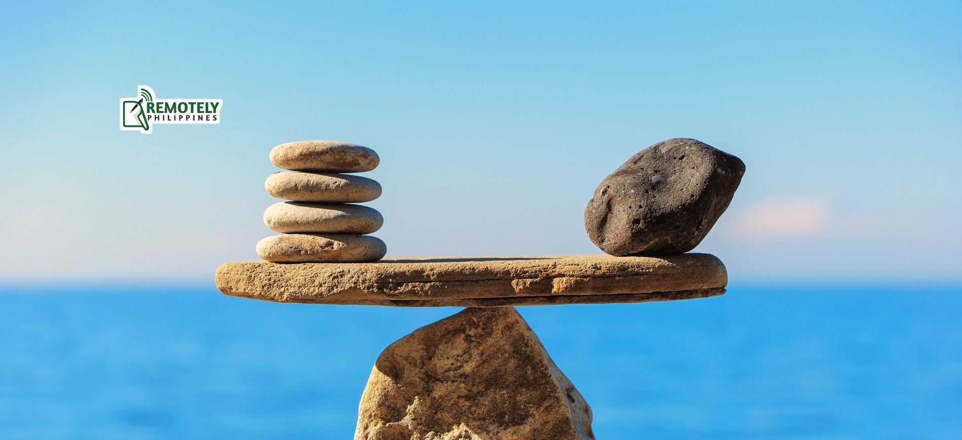 A pile of rocks sitting on top of each other in front of the ocean.