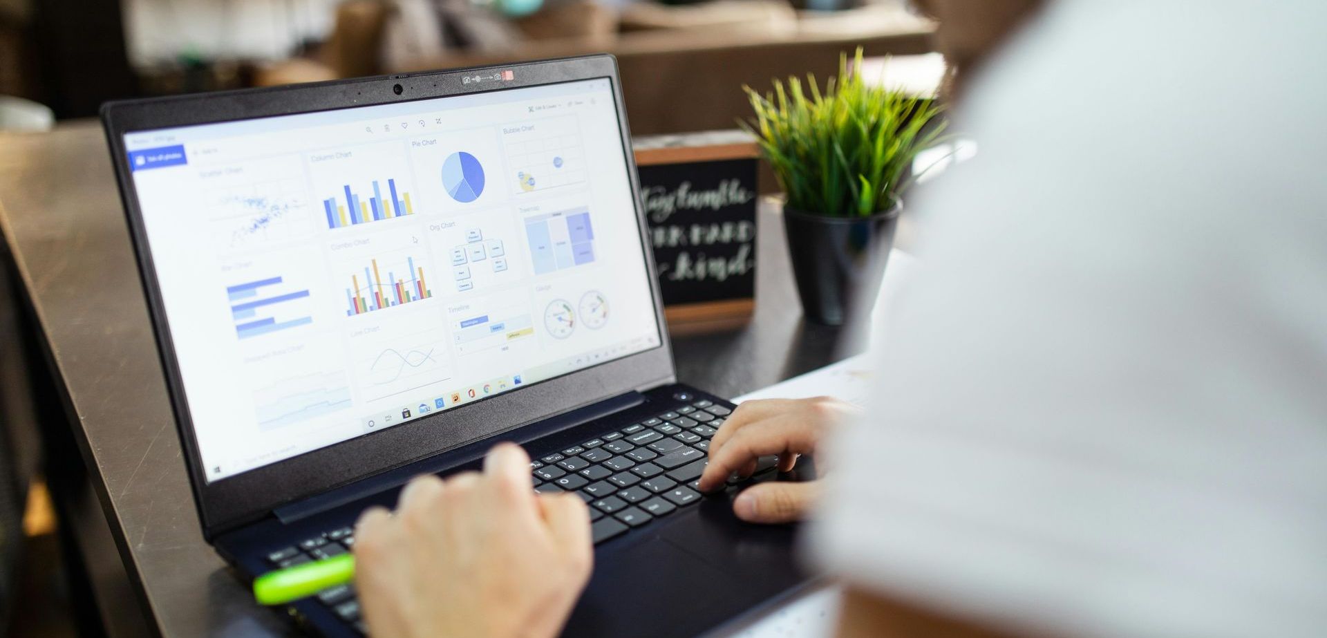 A person is typing on a laptop computer with a graph on the screen.