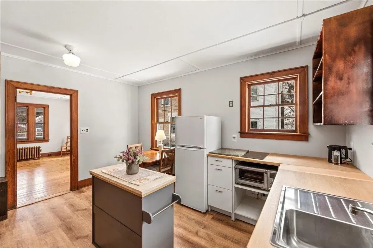 A newly renovated kitchen with fresh white walls and crisp wood trim by JG Services