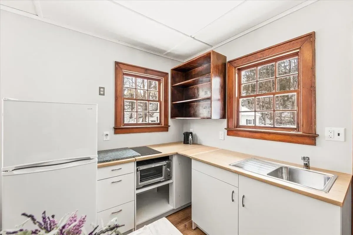 A newly renovated kitchen with fresh white walls and crisp wood trim by JG Services