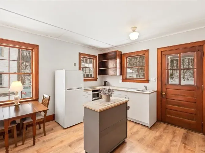 A newly renovated kitchen with fresh white walls and crisp wood trim by JG Services