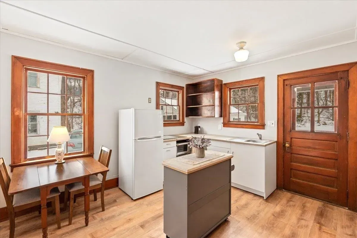 A newly renovated kitchen with fresh white walls and crisp wood trim by JG Services