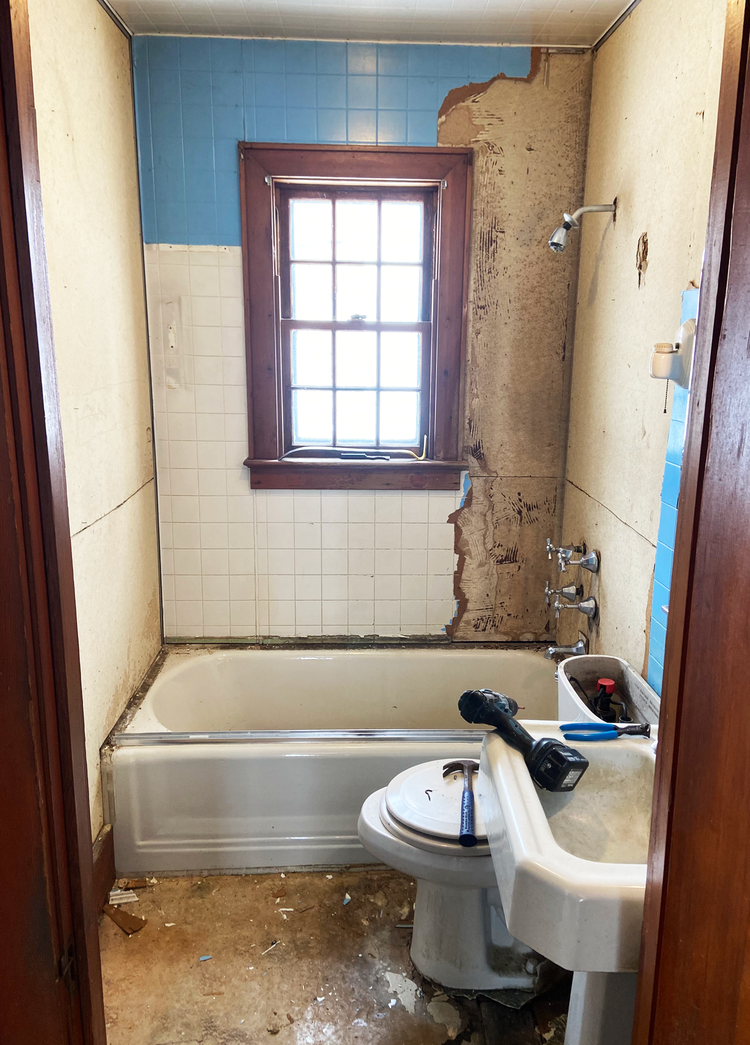 The BEFORE photo of a bathroom renovation before it was fixed by JG Services showing cracked tiles & major disrepair