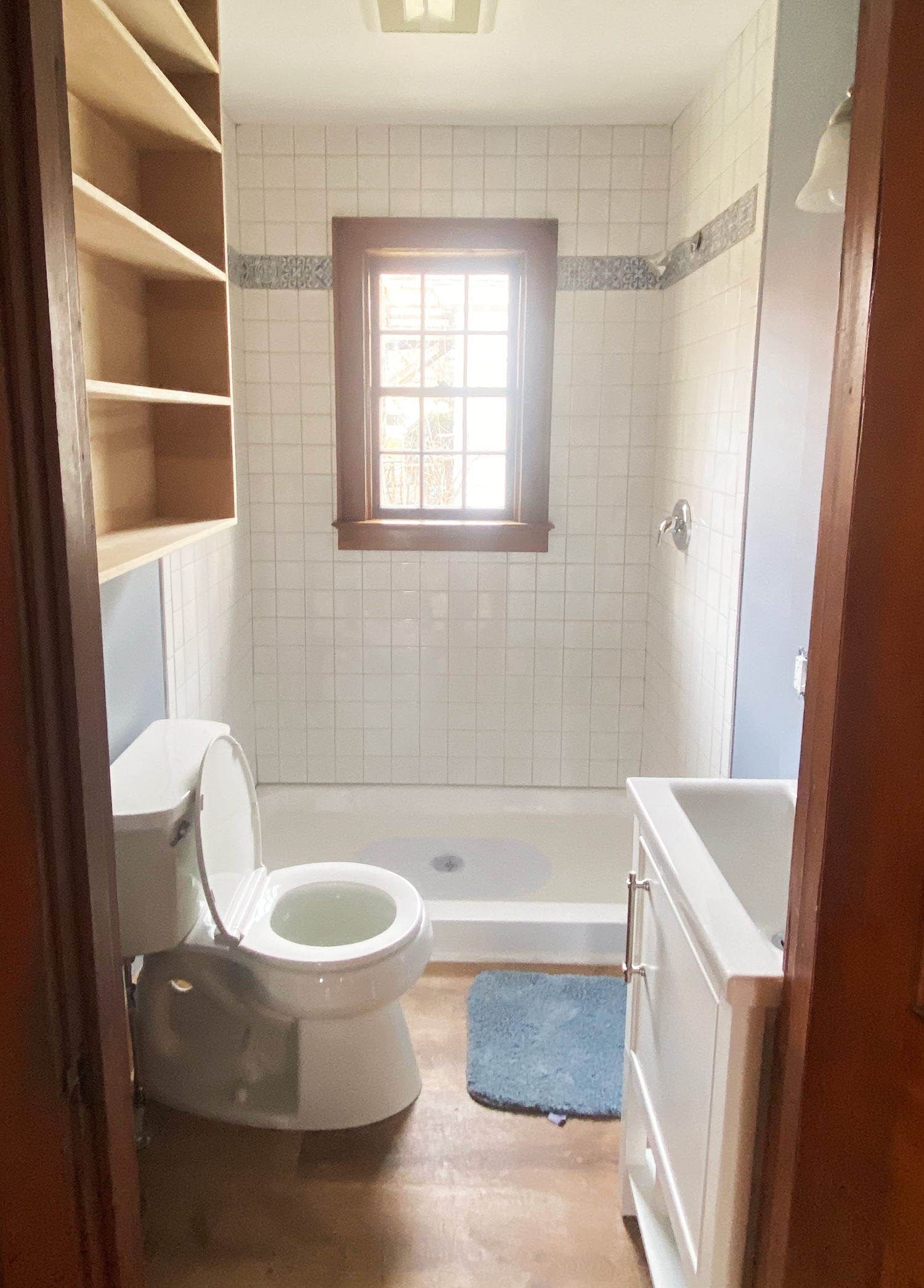 The AFTER picture of a bathroom renovation by JG Services from Londonderry Vermont crisp white tiles and new toilet