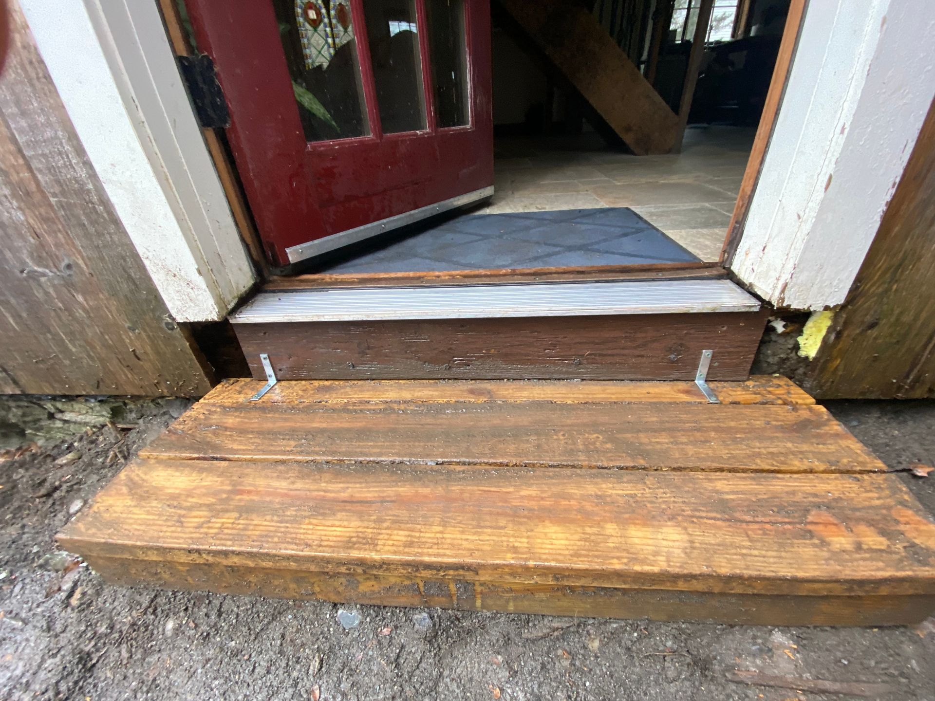The AFTER picture showing a repaired door jamb with a new wooden step