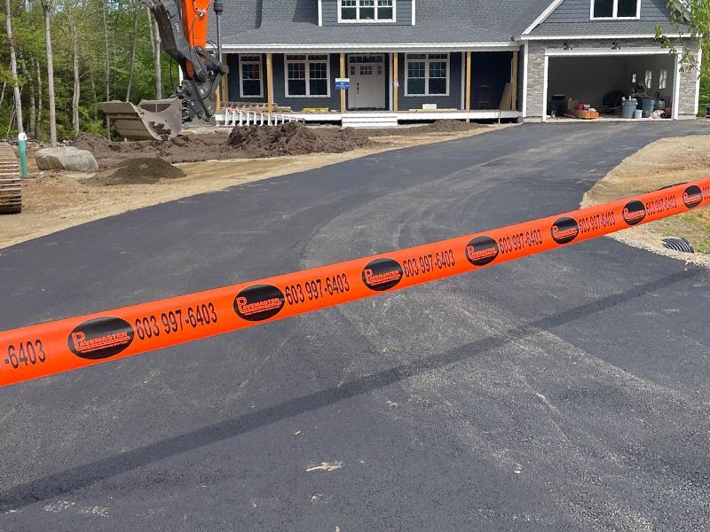 Orange construction tape blocks a driveway at a house with a garage under repair.