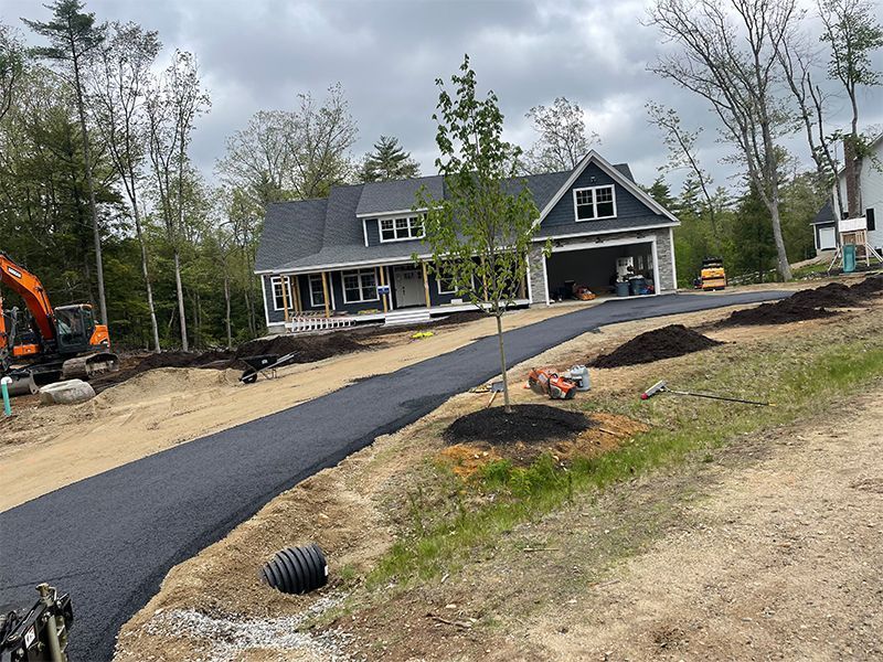 New home construction with newly paved driveway and landscaping.