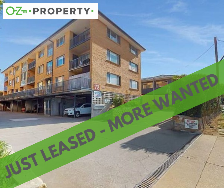 A building with a green sign that says just leased more wanted