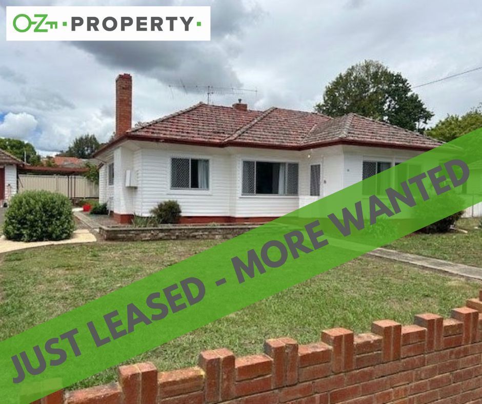 A white house with a green banner that says `` just leased - more wanted ''.