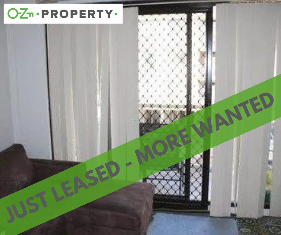 A living room with a couch and a sign that says `` just leased - more wanted ''