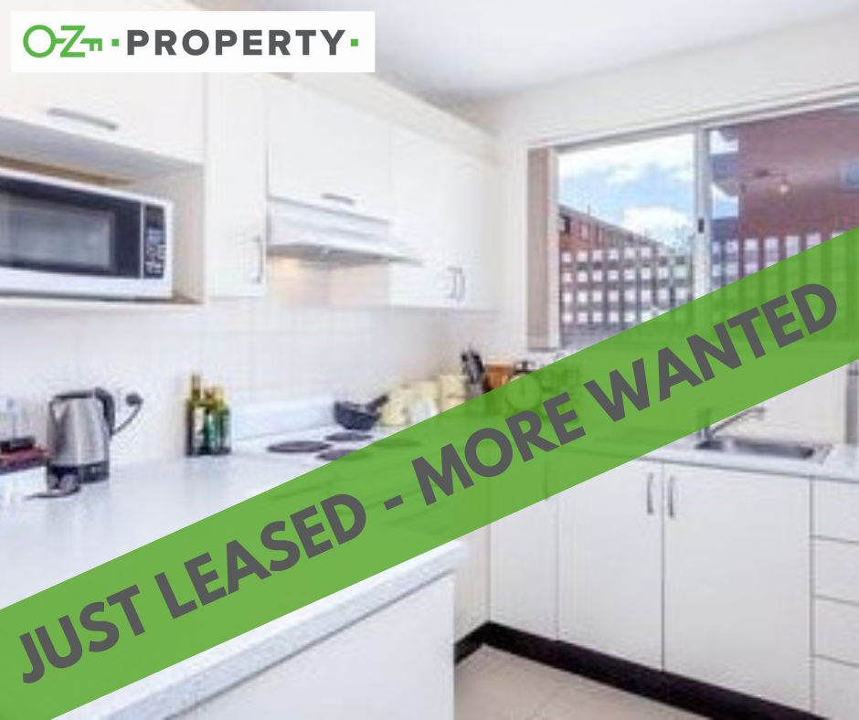 A kitchen with a green banner that says just leased more wanted