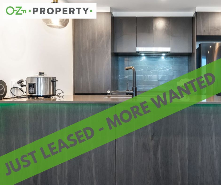 A kitchen with a green ribbon that says `` just leased - more wanted ''