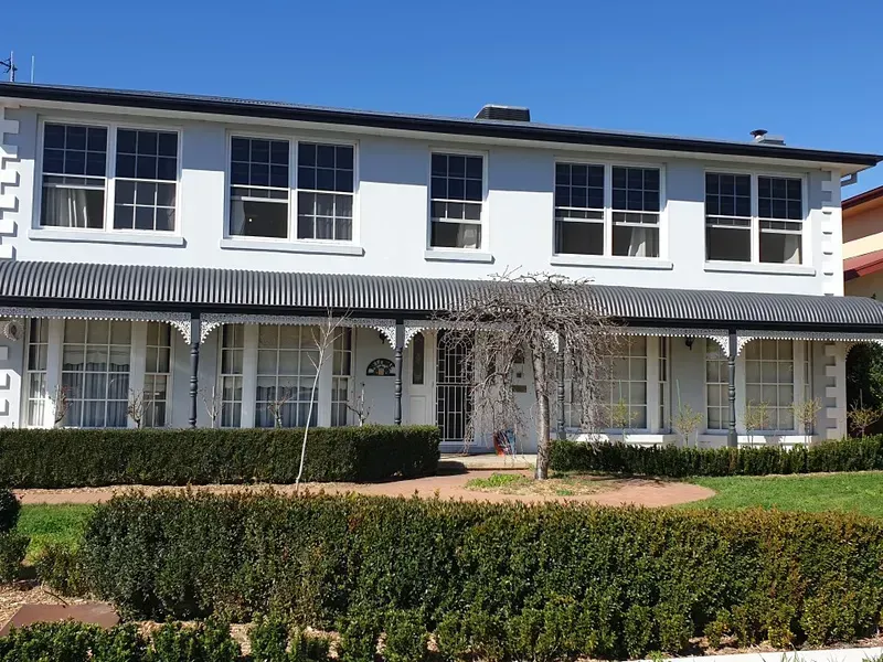 A large white house with a large porch and lots of windows