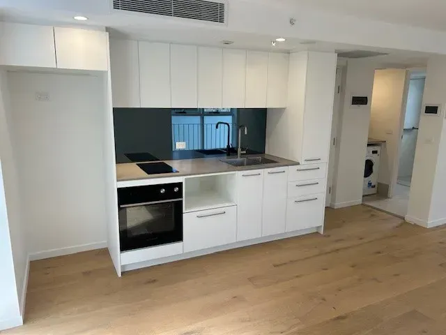 A kitchen with white cabinets and a black oven