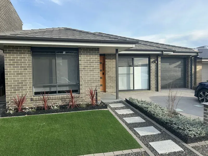 A brick house with a car parked in front of it