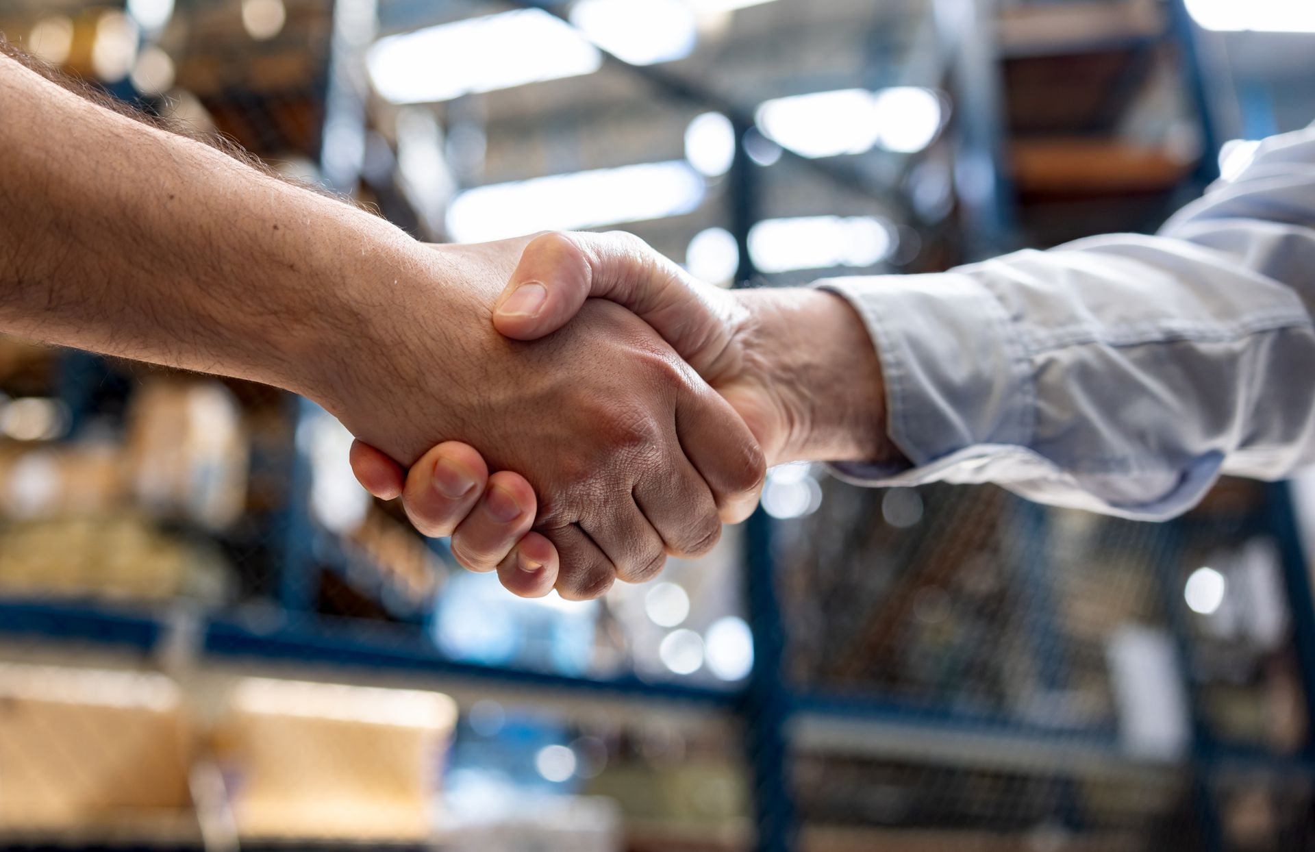 Due persone che si stringono la mano in un magazzino.