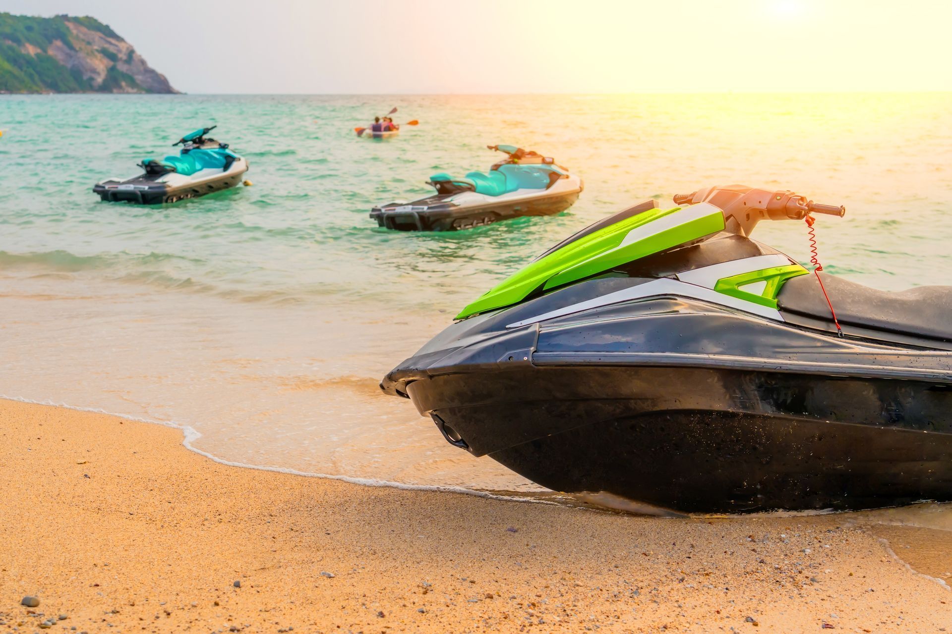 A jet ski is parked on the beach near the ocean.