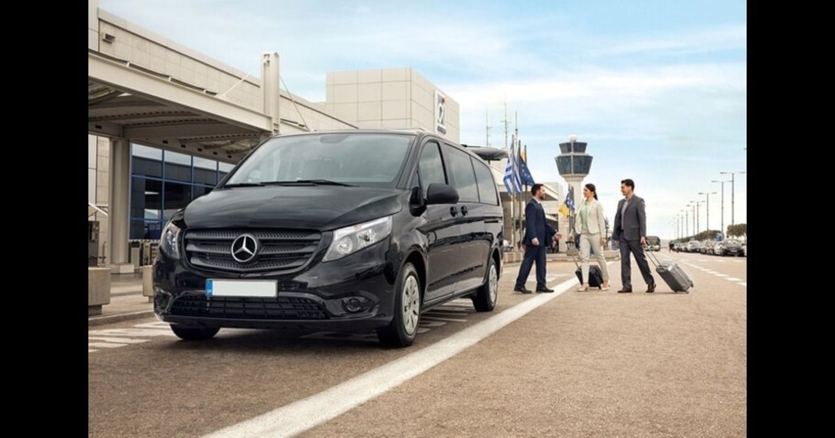 Professional driver assisting with luggage at Athens Airport for minivan transfer
