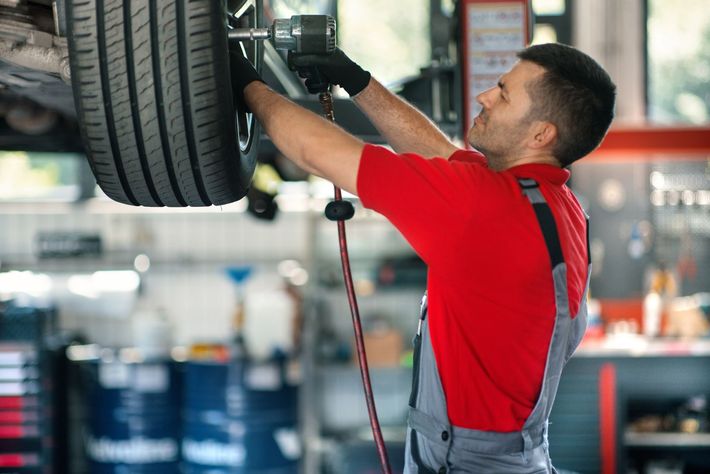 Car mechanic replacing a tyre.