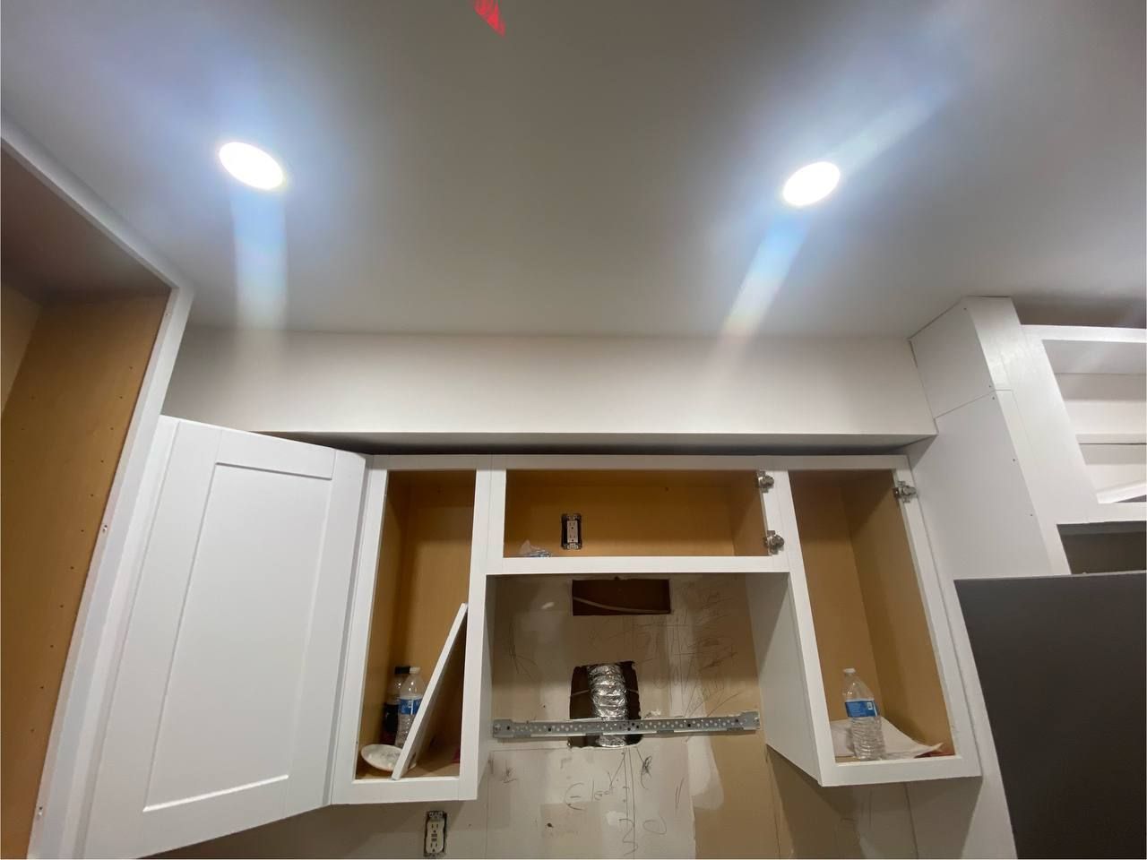 A kitchen with white cabinets and a ceiling light