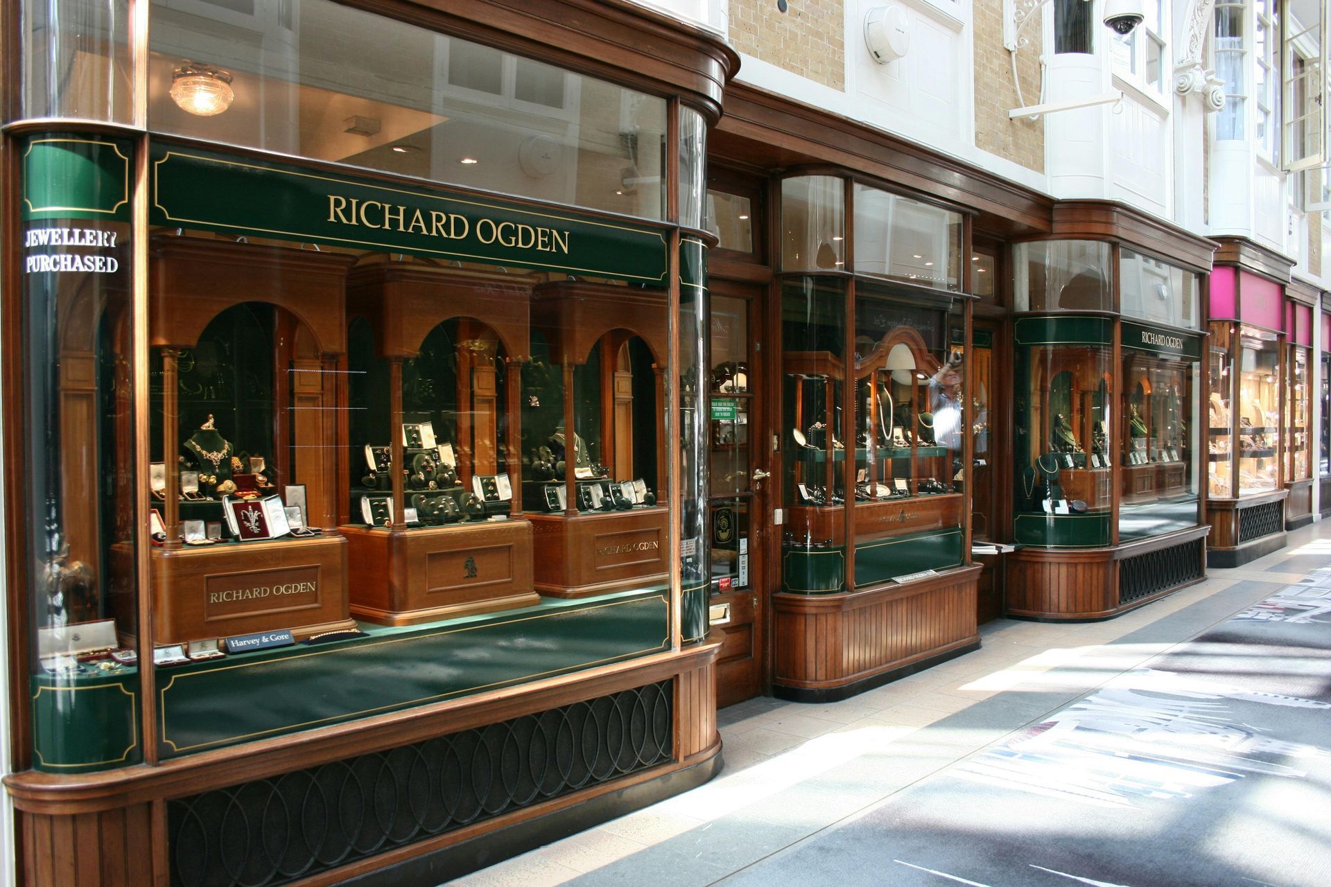 A row of shops with a green sign that says richard cox