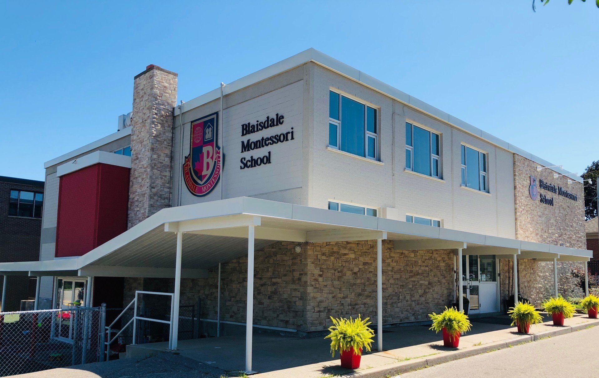 A large building with a canopy and a sign that says ' williamdale admission school ' on it.