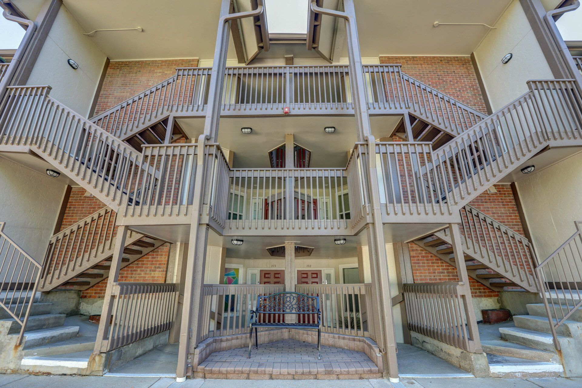 A large apartment building with stairs leading up to the second floor.