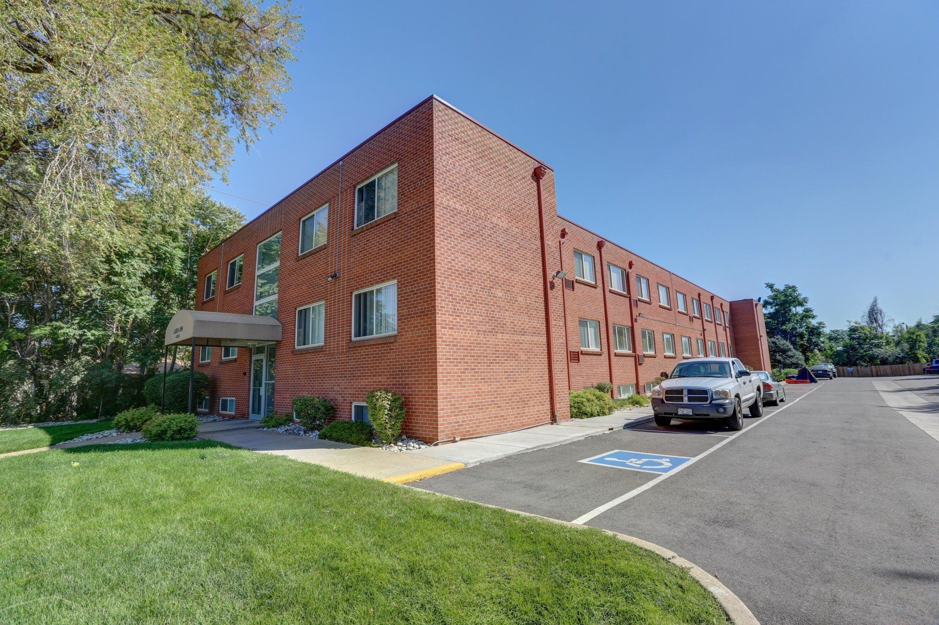 A large brick building with cars parked in front of it.