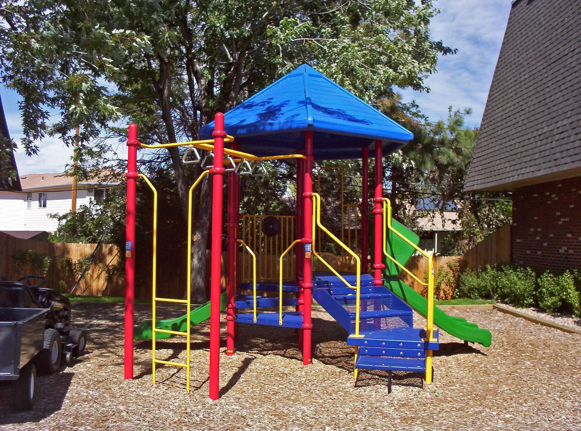 A colorful playground with a blue canopy and a green slide