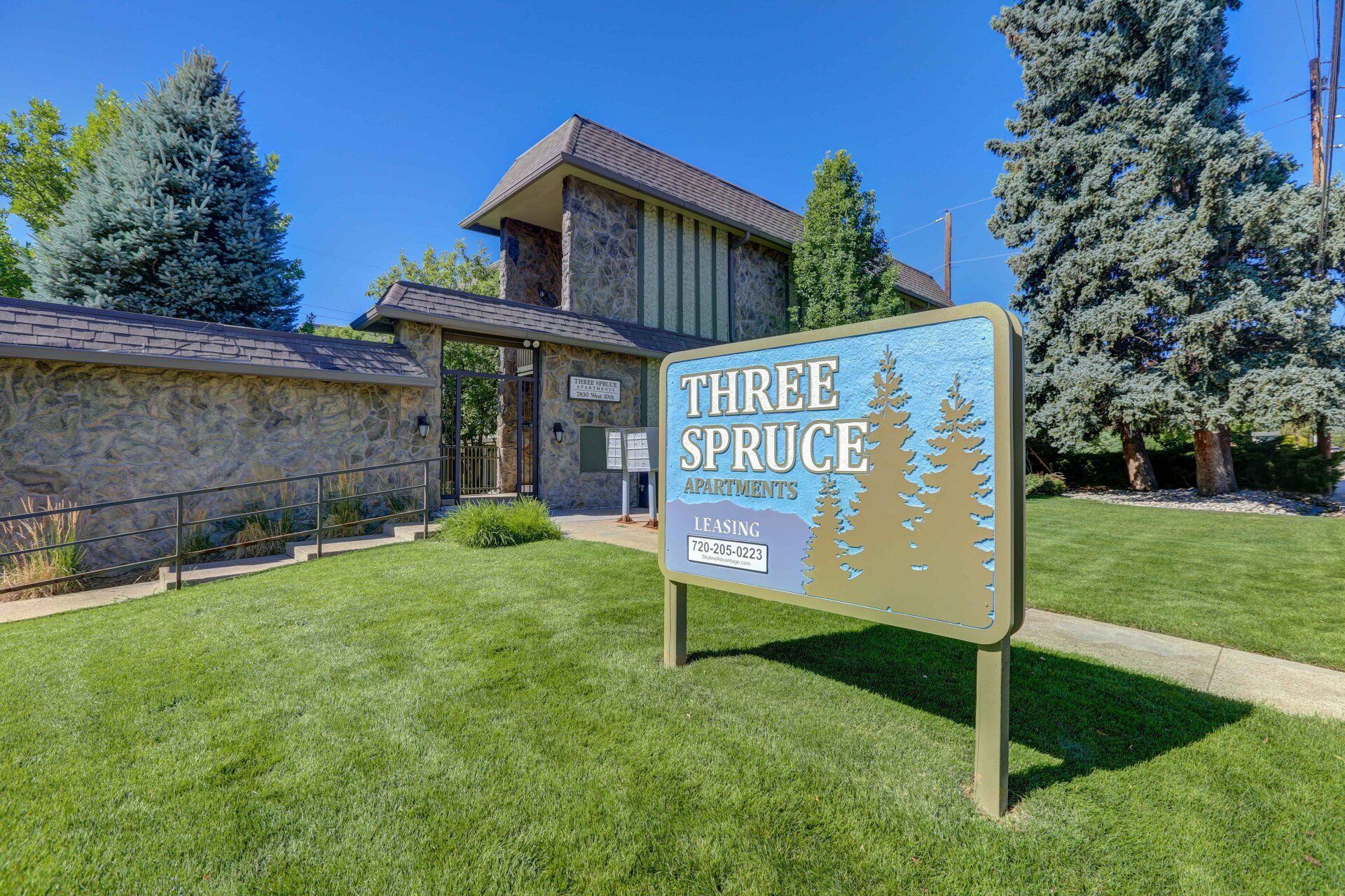 There is a sign in front of a building that says `` three spruce ''.