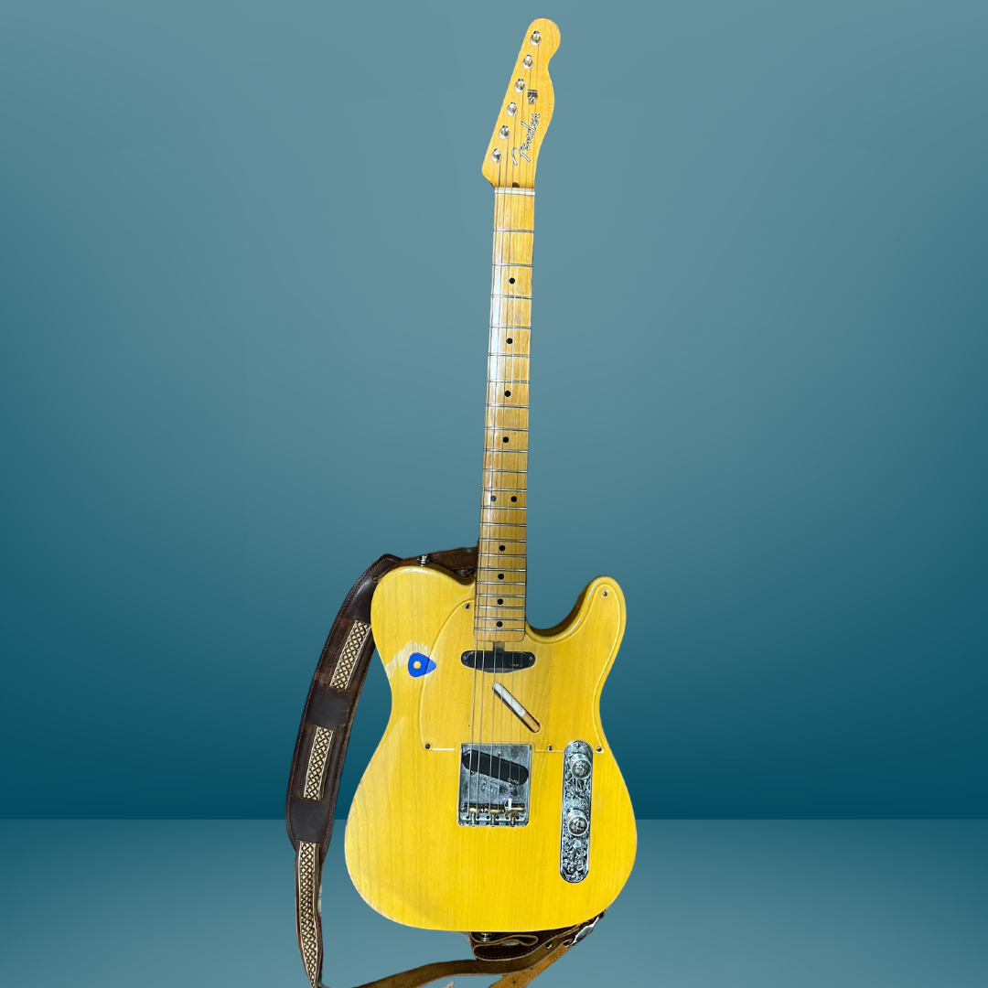 A yellow electric guitar with a black strap from Guitar Lessons with David Dunavant in Little Rock Arkansas