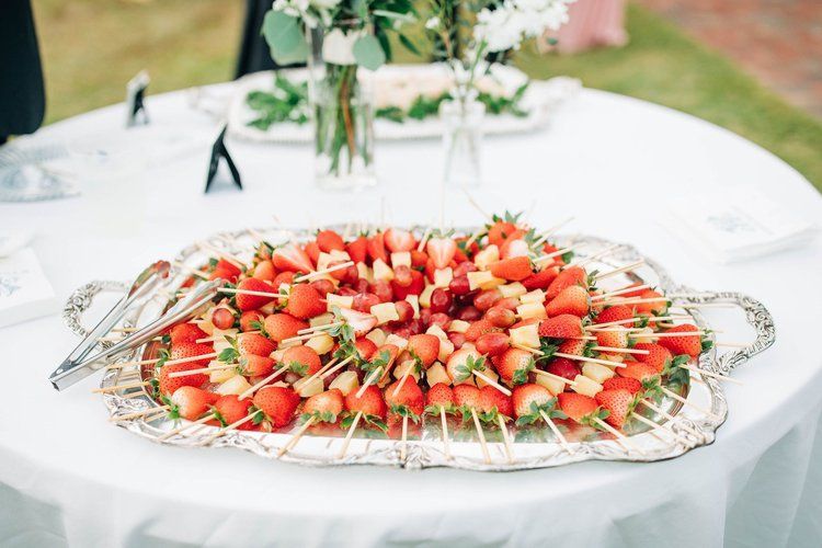 A tray of strawberries and watermelon on skewers on a table.