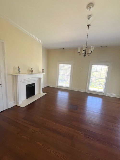 An empty living room with hardwood floors and a fireplace.