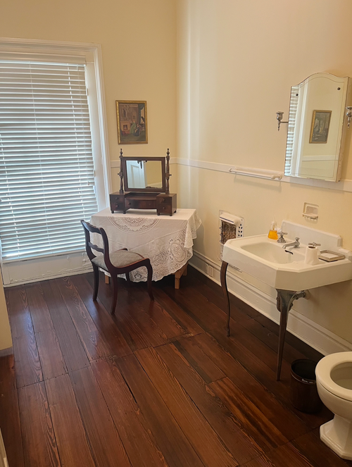 A bathroom with a sink , toilet and mirror.