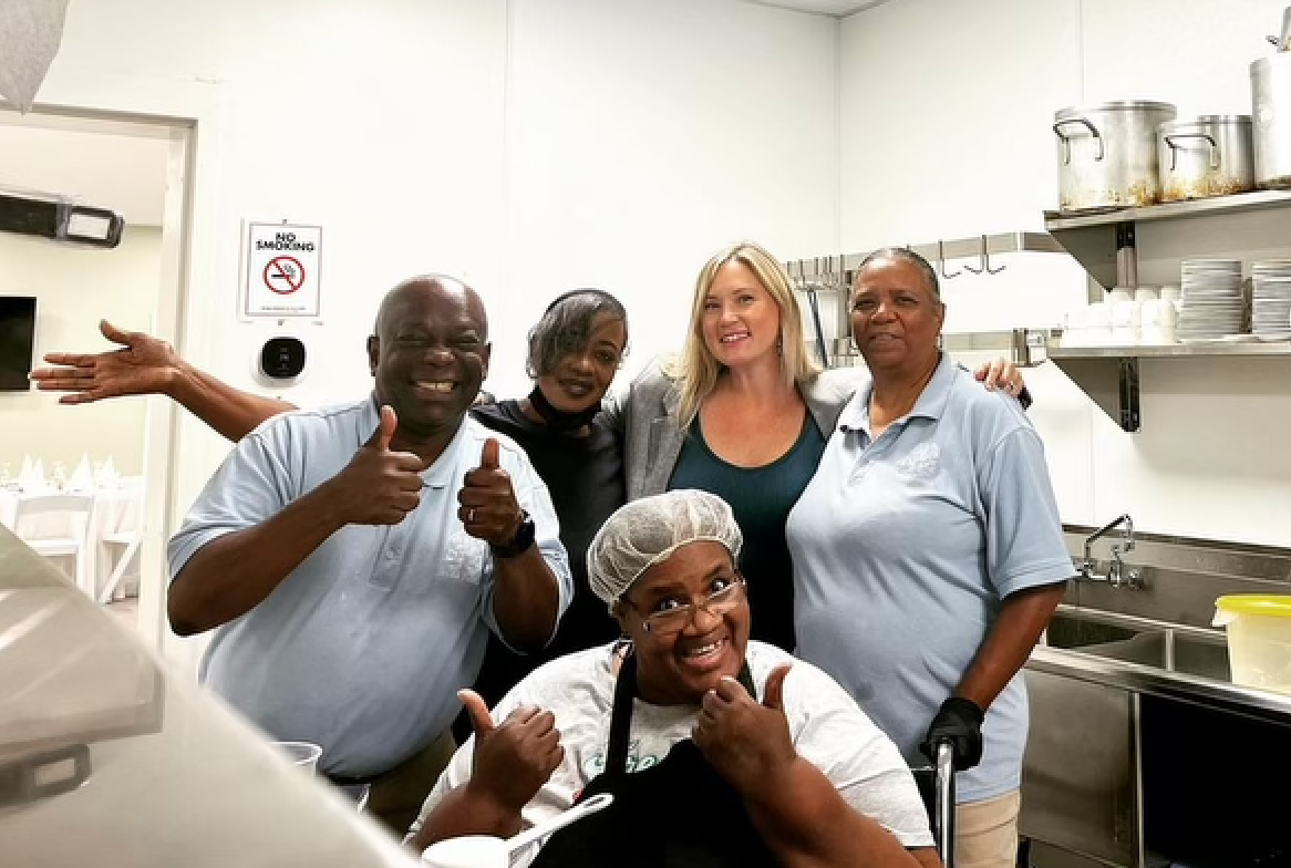 A group of people are posing for a picture in a kitchen.