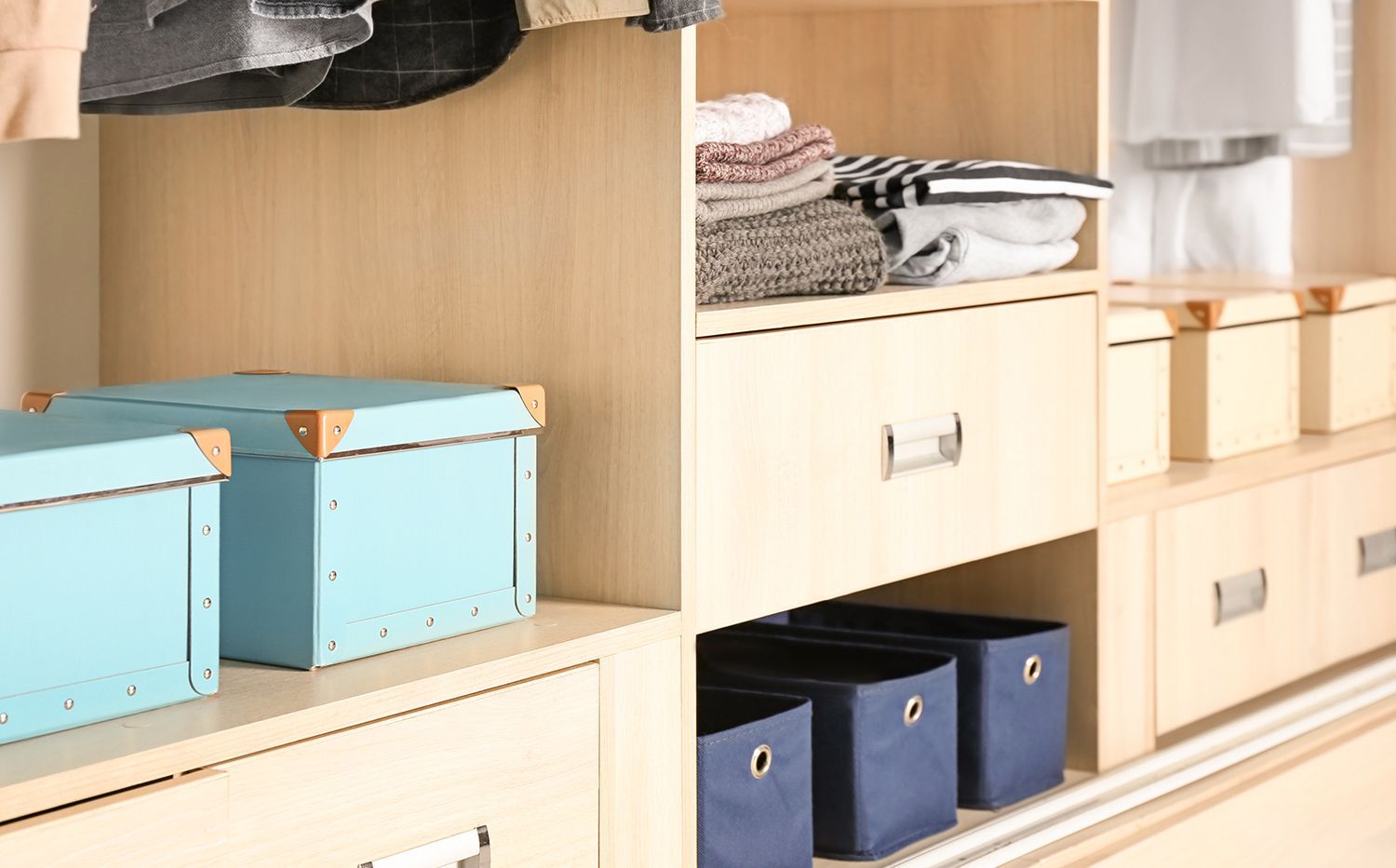 Built-in closet shelves with folded clothes and blue storage boxes in a tidy room